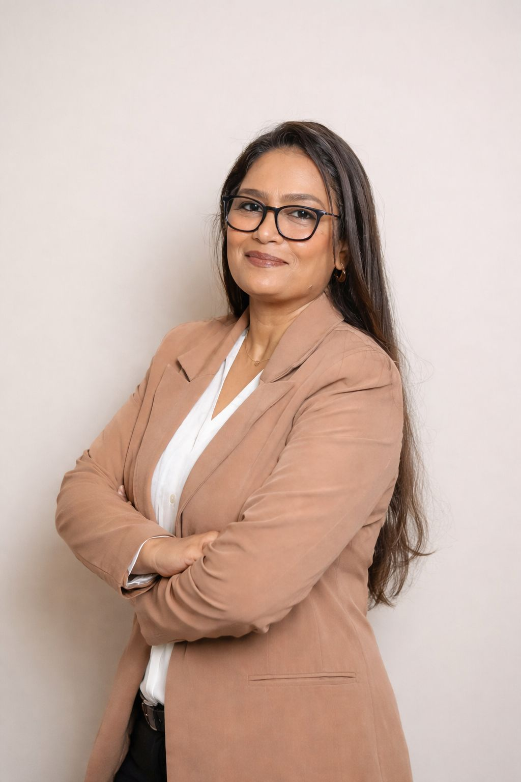 Leena Sawant, communication and mindset coach — professional portrait in a camel blazer