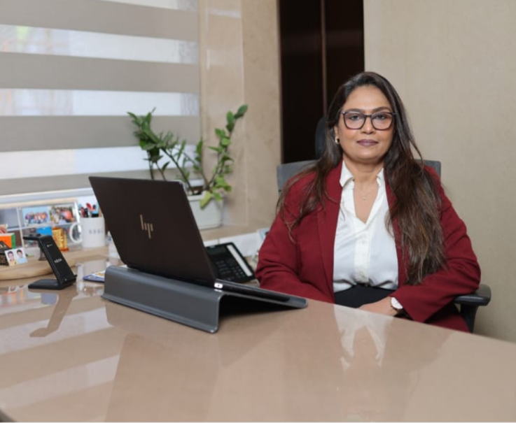 Leena Sawant at her desk with laptop — coaching and corporate communication